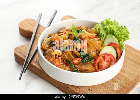 Kwetiaw o Kwetiau, tagliatelle piatte di riso fritto con pollo, polpette e verdure varie. Cibo cinese popolare in Indonesia Foto Stock