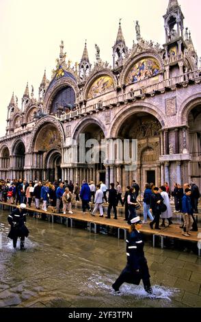 Persone su sentieri sopraelevati durante l'acqua alta Aqua alta a San Marco, Venezia, Italia Foto Stock