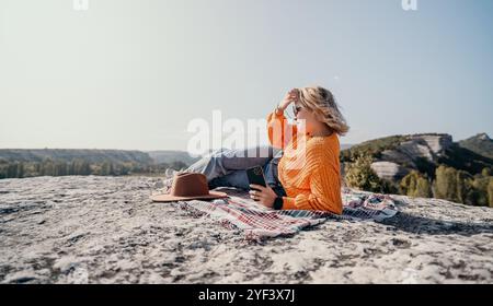 Donna che si rilassa sulla cima di una montagna con vista Foto Stock