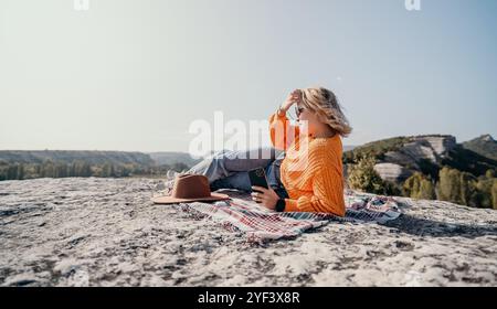 Donna che si rilassa sulla cima di una montagna con vista Foto Stock