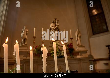 Una fila di candele accese collocate davanti alla statua della Vergine Maria nella Cattedrale di San Pietro Apostolo in TR Foto Stock