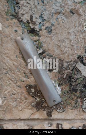 Una mezuzah affissa su un muro di pietra all'ingresso di una casa a Gerusalemme, Israele. Una mezuzah è un rotolo contenente versi scritturali che ricordano gli ebrei Foto Stock