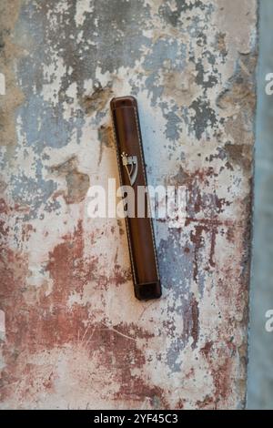 Una mezuzah affissa su un muro di pietra all'ingresso di una casa a Gerusalemme, Israele. Una mezuzah è un rotolo contenente versi scritturali che ricordano gli ebrei Foto Stock