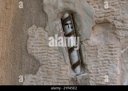 Una mezuzah affissa su un muro di pietra all'ingresso di una casa a Gerusalemme, Israele. Una mezuzah è un rotolo contenente versi scritturali che ricordano gli ebrei Foto Stock