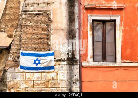Una bandiera israeliana esposta su uno dei vecchi edifici del Ghetto ebraico di Roma, in Italia. Foto Stock