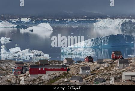 Grandi iceberg che galleggiano nel fiordo dietro l'insediamento Inuit Tiniteqilaaq, Sermilik Fjord, Groenlandia orientale, Groenlandia, Nord America Foto Stock