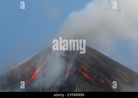 Paesaggio vulcanico della penisola di Kamchatka: Attivo Klyuchevskaya Sopka, vista della cima di un'eruzione vulcanica, flussi di lava sul pendio del vulcano, pennacchio di ga Foto Stock