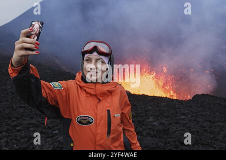 VULCANO TOLBACHIK, PENISOLA DI KAMCHATKA, ESTREMO ORIENTE RUSSO, 27 LUGLIO 2013: Eruzione del vulcano Tolbachik sulla Kamchatka, ragazza fotografata selfie sul backgrou Foto Stock