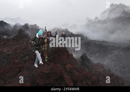 VULCANO TOLBACHIK, PENISOLA DI KAMCHATKA, ESTREMO ORIENTE RUSSO, 27 LUGLIO 2013: Gruppo di turisti che fanno escursioni sul campo di lava eruzione vulcano Tolbachik attivo Foto Stock