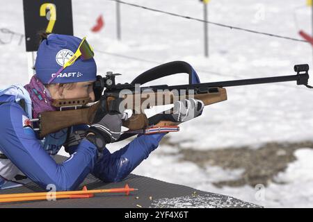 Sportiva biatleta che mira, fucile che spara in posizione prona. Kamchatka biatleta Maria Miroshnichenko nel poligono di tiro. Competitio di biathlon junior Foto Stock