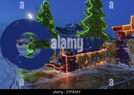 PETROPAVLOVSK CITY, PENISOLA DI KAMCHATKA, RUSSIA, DEC 30, 2018: Vista notturna della composizione festiva illuminata con un'iscrizione in Russian Happy New Foto Stock