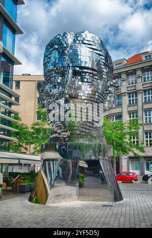 PRAGA - 12 MAGGIO 2024: Scultura cinetica in metallo di David Cherny della testa di Franz Kafka che ruota di fronte all'architettura moderna a Praga, Repubblica Ceca Foto Stock