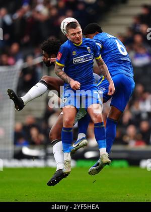 Ellis Harrison di Milton Keynes Dons (a sinistra) combatte contro James Tilley (centro) della AFC Wimbledon e Ryan Johnson durante la partita del primo turno della Emirates fa Cup allo Stadium MK, Milton Keynes. Data foto: Domenica 3 novembre 2024. Foto Stock