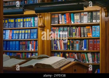 Libri aperti su scrivanie e scaffali in legno nella Lincoln's Inn Library di Londra, Inghilterra. Foto Stock