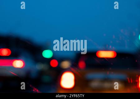 Una fotografia leggermente poco chiara mostra varie auto che navigano lungo un'autostrada durante le ore notturne, illuminate da lampioni Foto Stock