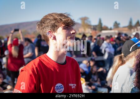 Salem, Virginia, Stati Uniti. 2 novembre 2024. I sostenitori di Donald Trump si sono riuniti a Salem, Virginia, il 2 novembre 2024, per un raduno in cui hanno applaudito e guardato i discorsi su un grande schermo fuori dalla sede. Le linee iniziarono a formarsi già alle 4 del mattino, con molte che aspettavano fino a dieci ore senza essere in grado di entrare a causa della dimensione della folla. Anche se i partecipanti hanno mostrato un sostegno entusiasta per Trump, il tono dell'evento è stato caratterizzato da indignazione e risentimento, con oratori che hanno trasmesso messaggi arrabbiati che hanno risuonato con l'umore della folla, un mix di rabbia, lamentele e malcontento. Credito: Diego Montoya Foto Stock