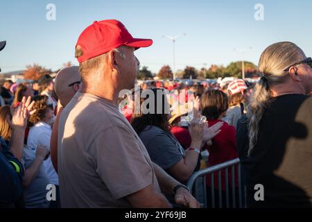 Salem, Virginia, Stati Uniti. 2 novembre 2024. I sostenitori di Donald Trump si sono riuniti a Salem, Virginia, il 2 novembre 2024, per un raduno in cui hanno applaudito e guardato i discorsi su un grande schermo fuori dalla sede. Le linee iniziarono a formarsi già alle 4 del mattino, con molte che aspettavano fino a dieci ore senza essere in grado di entrare a causa della dimensione della folla. Anche se i partecipanti hanno mostrato un sostegno entusiasta per Trump, il tono dell'evento è stato caratterizzato da indignazione e risentimento, con oratori che hanno trasmesso messaggi arrabbiati che hanno risuonato con l'umore della folla, un mix di rabbia, lamentele e malcontento. Credito: Diego Montoya Foto Stock