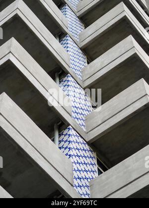 Una vista dettagliata di un edificio moderno che mostra audaci motivi geometrici in piastrelle blu e bianche, creando una composizione della facciata visivamente accattivante. Foto Stock