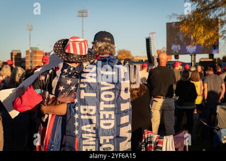 Salem, Virginia, Stati Uniti. 2 novembre 2024. I sostenitori di Donald Trump si sono riuniti a Salem, Virginia, il 2 novembre 2024, per un raduno in cui hanno applaudito e guardato i discorsi su un grande schermo fuori dalla sede. Le linee iniziarono a formarsi già alle 4 del mattino, con molte che aspettavano fino a dieci ore senza essere in grado di entrare a causa della dimensione della folla. Anche se i partecipanti hanno mostrato un sostegno entusiasta per Trump, il tono dell'evento è stato caratterizzato da indignazione e risentimento, con oratori che hanno trasmesso messaggi arrabbiati che hanno risuonato con l'umore della folla, un mix di rabbia, lamentele e malcontento. Credito: Diego Montoya Foto Stock