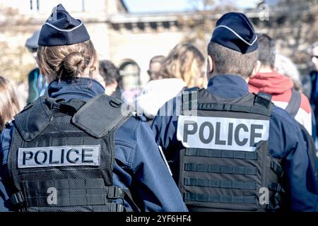 Due poliziotti, un uomo e una donna, che indossano un giubbotto antiproiettile con la parola "polizia". Parigi, Francia - 1 novembre 2024 Foto Stock