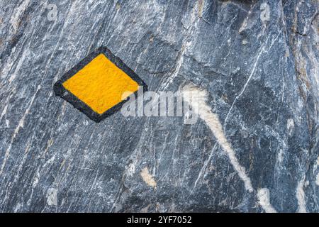 Marcatore giallo del sentiero escursionistico su una roccia, turismo pedonale in Svizzera Foto Stock