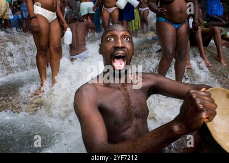 Uno de los peregrinos asistentes al festival de vudú ingresso en trance. SUS gritos mientras está poseido son admirados por el resto de asistentes. Como Foto Stock