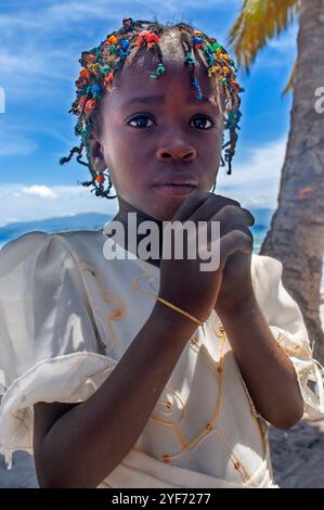 Ragazza vestita per la messa domenicale in una chiesa improvvisata a Cayes-à-l'eau, un isolotto di pescatori situato a nord-est di Caye Grand Gosie, Île-à-Vache, Sud Pro Foto Stock