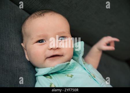 Ritratto di un bambino sorridente disteso su un divano Foto Stock