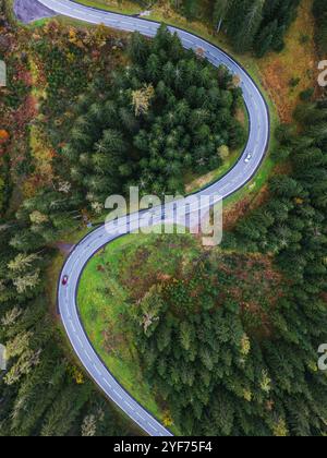 Vista aerea delle auto che guidano su una strada che si snoda attraverso una foresta autunnale, Salisburgo, Austria Foto Stock