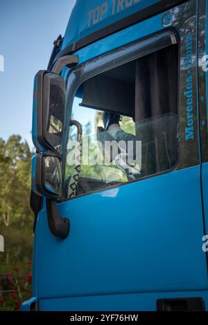 Amman, Giordania - 29 aprile 2023: Camionista che fa una pausa dormendo nel suo camion sollevando i piedi sullo sterzo e sul cruscotto Foto Stock