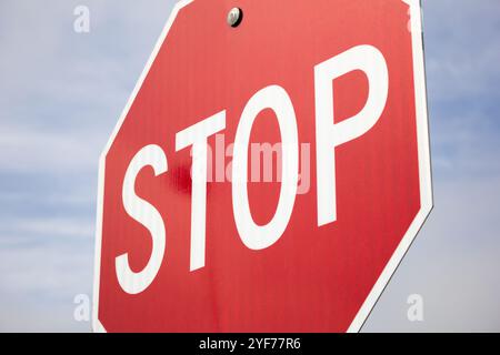 Una vista angolata di uno stop comune, con nuvole e un cielo blu sullo sfondo. Foto Stock