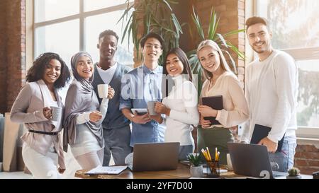 Un team giovane e felice che si occupa di lavoro durante il giorno lavorativo Foto Stock
