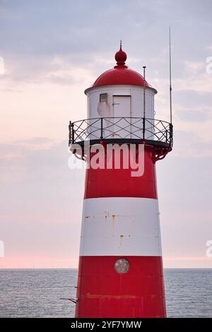 In cima a un bellissimo faro sulla costa olandese del Mare del Nord al tramonto, Paesi Bassi, Zelanda, Westkapelle Foto Stock