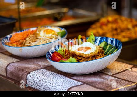 Piatti di noodle all'One Pan Noodle Bar, al South Bank Christmas Market, Londra, Inghilterra Foto Stock