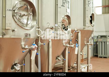 Serbatoi di fermentazione industriali in acciaio inox in una fabbrica di birra Foto Stock