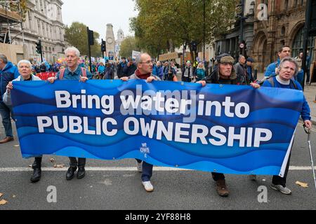 March for Water Proprotetesters tiene uno striscione che chiede che le aziende idriche vengano riportate di nuovo di proprietà pubblica. Foto Stock