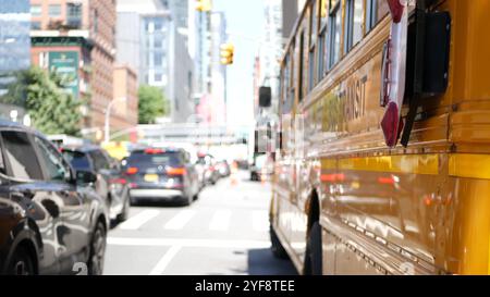 Scuolabus giallo su New York Manhattan Street, scuolabus sulla trafficata strada cittadina. Educazione e trasporto per bambini, USA. Navetta per la scuola americana nel traffico, 10 avenue Chelsea, Stati Uniti. Foto Stock