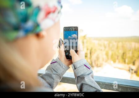 Una ragazza scatta delle foto sul suo telefono in montagna. Foto ravvicinata. Foto Stock