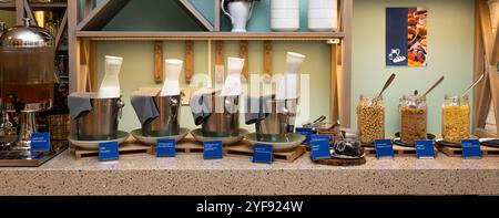 Elegante colazione a buffet con cereali e latte in un ambiente moderno in hotel Foto Stock