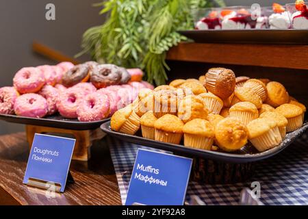 Deliziose ciambelle e muffin in in esposizione ad una colazione a buffet dolce in hotel Foto Stock
