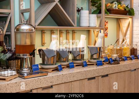 Ricca scelta di piatti con succhi di frutta, cereali e latticini in un moderno ambiente a buffet in hotel Foto Stock