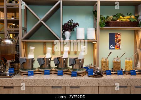 Elegante colazione a buffet con cereali e latte in un ambiente moderno in hotel Foto Stock