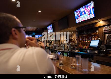 I clienti di un bar di Chicago, Illinois, osservano i risultati delle elezioni presidenziali degli Stati Uniti del 2016 annunciati in televisione. Foto Stock