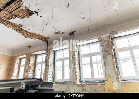 Sono in corso estesi lavori di ristrutturazione all'interno di un vecchio edificio con mattoni a vista e materiali impilati Foto Stock