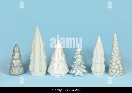 Alberi di Natale in ceramica verde chiaro di diversa forma su sfondo blu Foto Stock