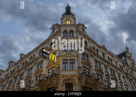 VIENNA, AUSTRIA - 10 AGOSTO 2024: Storico edificio barocco con cartello illuminato del McDonald's su Karntner Strasse. Il suggestivo cielo serale incornicia l'architec Foto Stock
