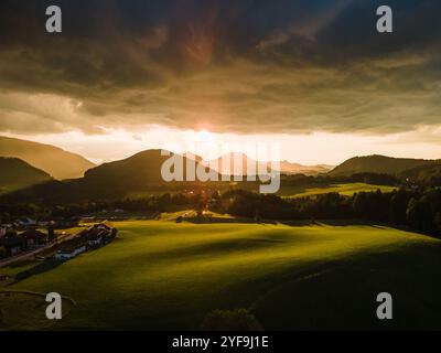 Tramonto d'oro che proietta una luce calda sulle Rolling Hills nella campagna austriaca Foto Stock