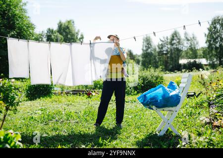 Tutta la lunghezza della madre che trasporta il bambino appeso alla stoffa del bucato Foto Stock