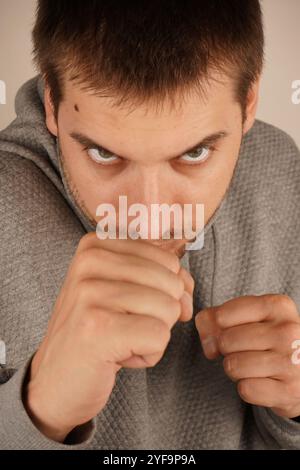 Usare la forza per autodifesa. L'uomo barbuto sta in piedi con i pugni stretti. In posizione difensiva. Combattere l'azione difensiva. Lotta e competizione Foto Stock