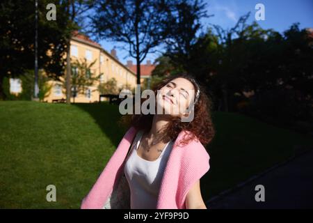 Giovane donna spensierata con gli occhi chiusi al parco Foto Stock